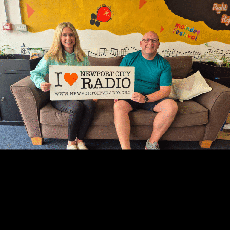 Lamsie sat on sofa with Laura from Newport West Netball